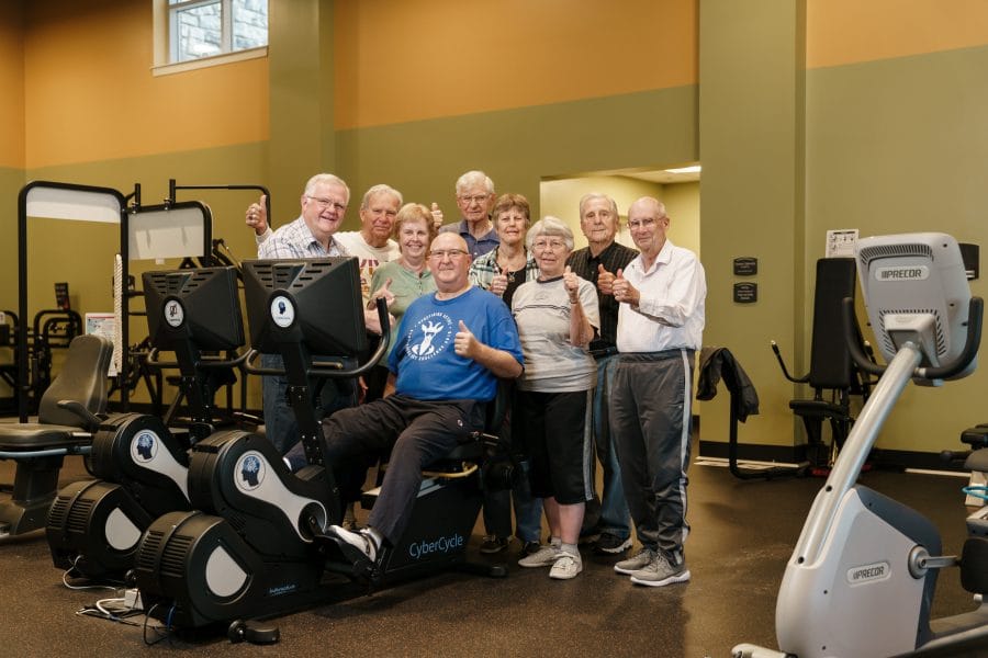 Woodcrest Villa residents posing for a photo with gym equipment